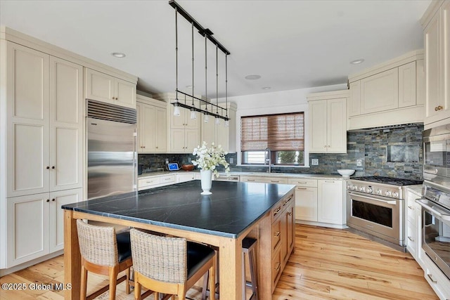 20 Oak Ridge Blvd, Saratoga Springs, NY 12866 - kitchen featuring a kitchen island, tasteful backsplash, a sink, light wood finished floors, and built in appliances