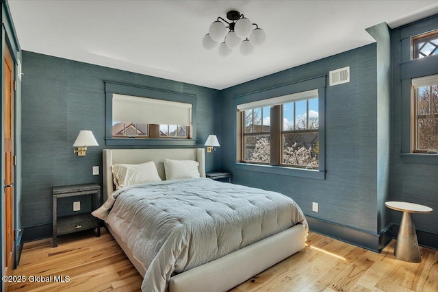 20 Oak Ridge Blvd, Saratoga Springs, NY 12866 - bedroom with visible vents, wood finished floors, and an inviting chandelier