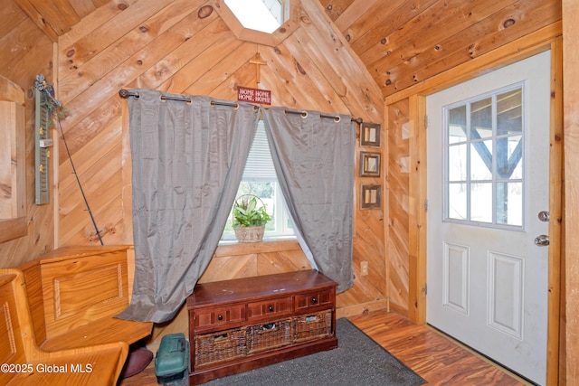 entryway featuring wooden walls, vaulted ceiling, and wood finished floors