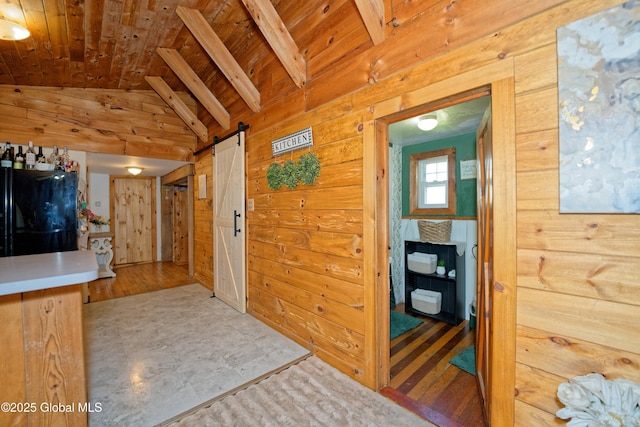 interior space featuring wooden walls, wooden ceiling, vaulted ceiling with beams, and a barn door
