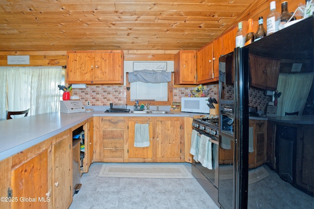 kitchen with white microwave, light countertops, wood ceiling, a sink, and gas stove