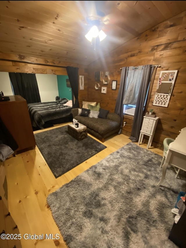 bedroom with wooden walls, wooden ceiling, wood finished floors, and lofted ceiling
