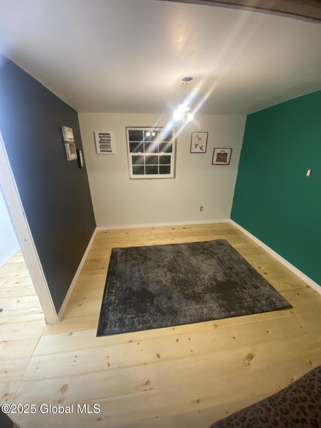 basement featuring baseboards and wood finished floors