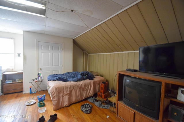 bedroom featuring wood finished floors and lofted ceiling