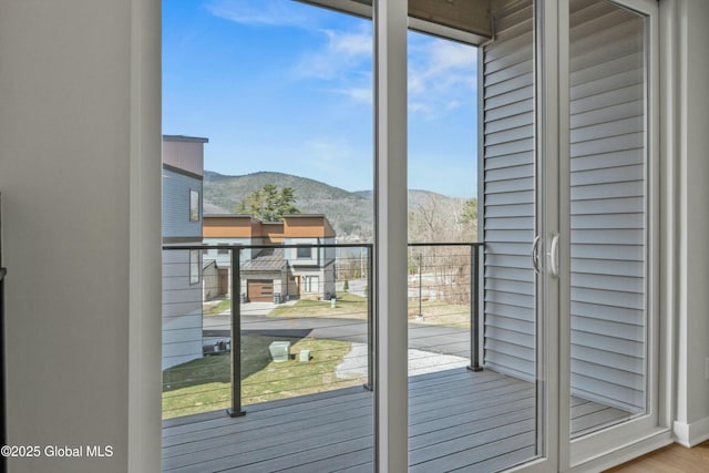 doorway with a mountain view, wood finished floors, and a wealth of natural light