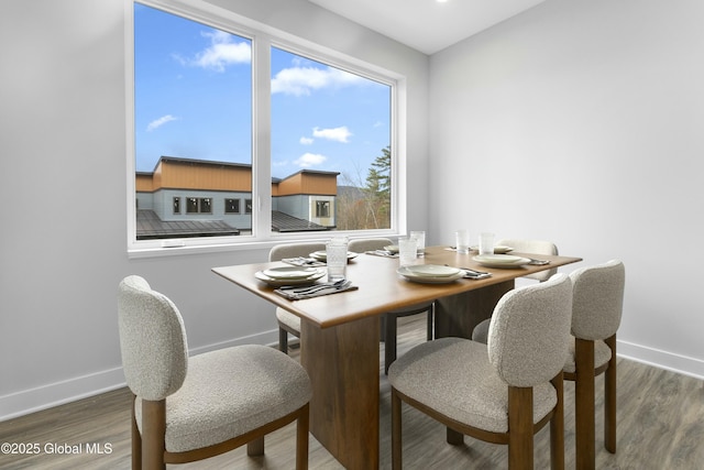 dining area with baseboards and wood finished floors