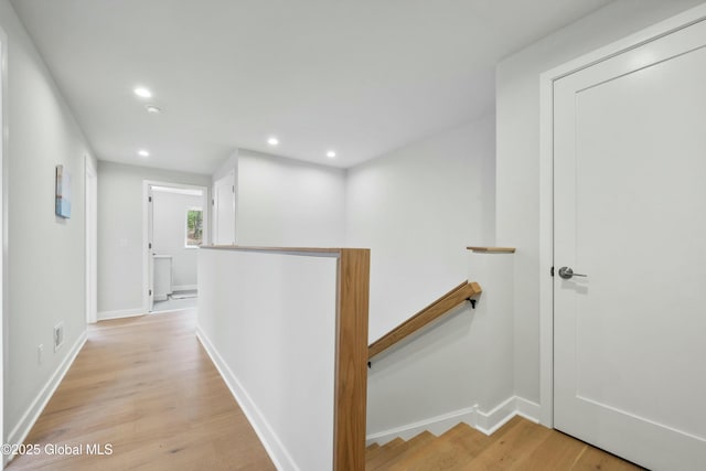 corridor with recessed lighting, baseboards, an upstairs landing, and light wood finished floors