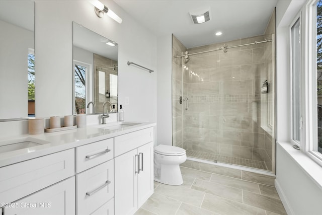 full bathroom with a sink, double vanity, toilet, visible vents, and a stall shower