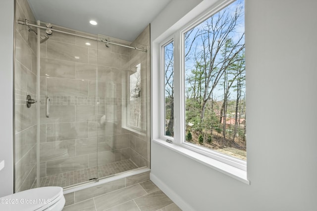 full bath featuring toilet, marble finish floor, recessed lighting, baseboards, and a shower stall