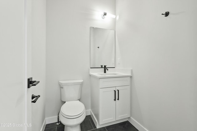 half bath with baseboards, tile patterned flooring, toilet, and vanity