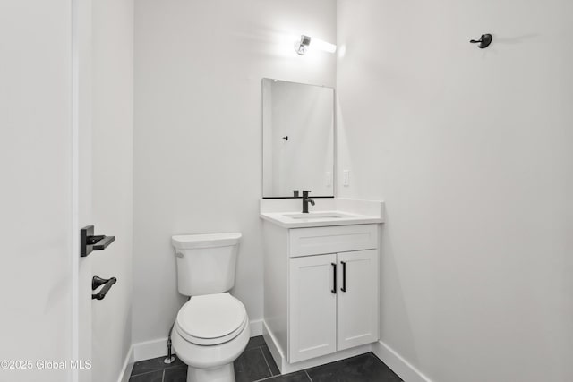 bathroom featuring vanity, baseboards, toilet, and tile patterned floors