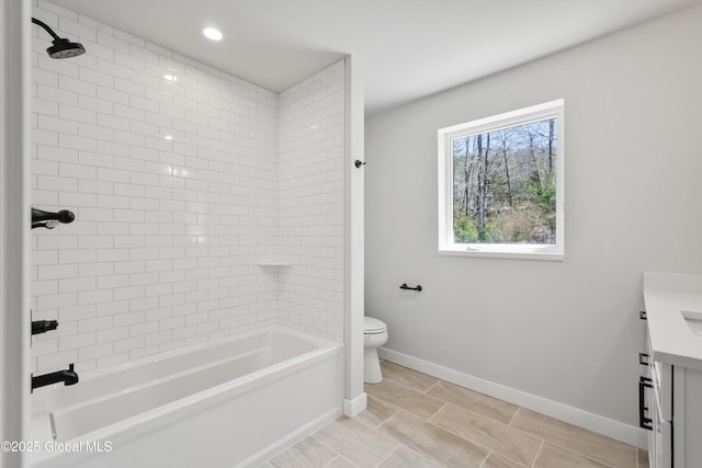 bathroom with vanity, baseboards, bathing tub / shower combination, and toilet