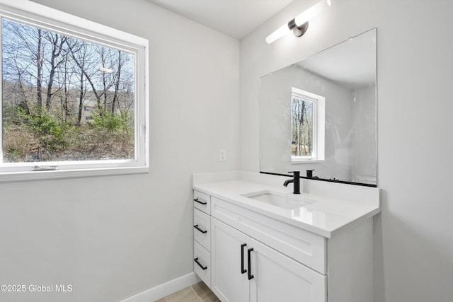 bathroom featuring vanity, plenty of natural light, and baseboards