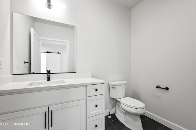 bathroom with baseboards, tile patterned flooring, vanity, and toilet