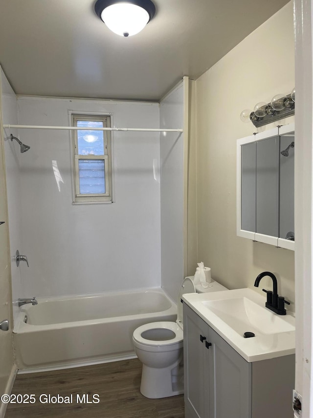 full bath featuring wood finished floors, toilet, bathtub / shower combination, and vanity