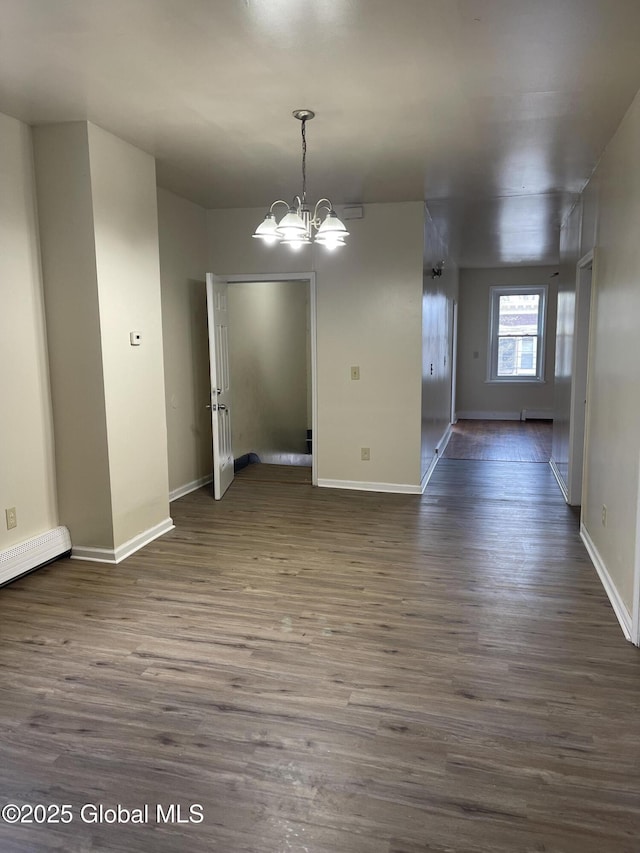 unfurnished room featuring dark wood finished floors, baseboards, a notable chandelier, and baseboard heating
