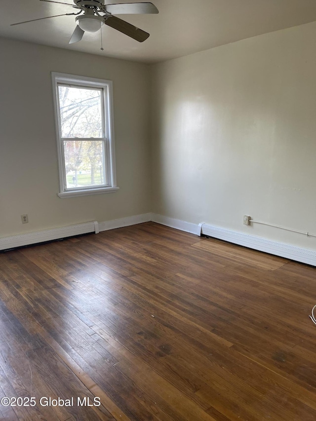 spare room featuring dark wood finished floors, a baseboard heating unit, baseboard heating, ceiling fan, and baseboards