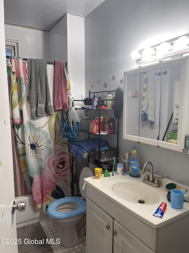 full bath featuring toilet, tile patterned floors, shower / tub combo with curtain, and vanity