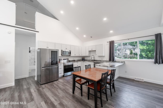 23 Locust Ridge Dr, Corinth, NY 12822 - kitchen with appliances with stainless steel finishes, a sink, high vaulted ceiling, baseboards, and white cabinetry