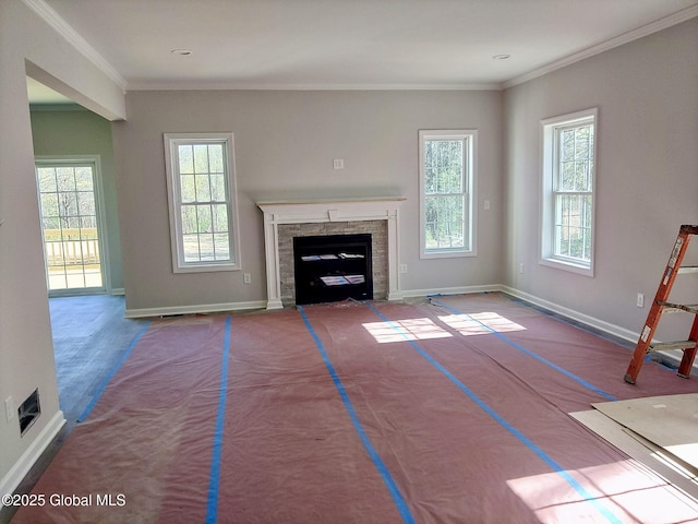 unfurnished living room with baseboards, ornamental molding, and a fireplace