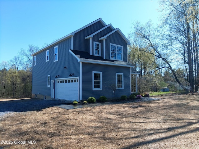 view of property exterior featuring dirt driveway and a garage