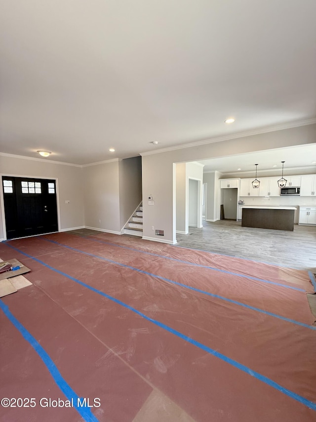 unfurnished living room with crown molding, baseboards, stairway, and recessed lighting