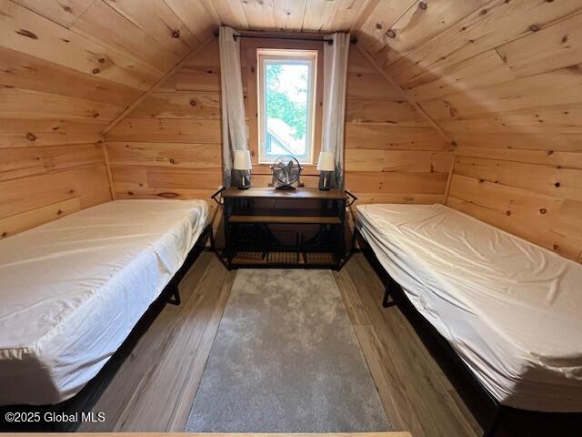 15-17 Pine Rd, Lake Luzerne, NY 12846 - bedroom with wood walls, wood finished floors, vaulted ceiling, and wooden ceiling