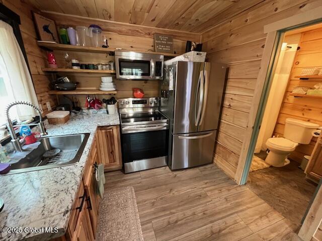 15-17 Pine Rd, Lake Luzerne, NY 12846 - kitchen featuring wood ceiling, a sink, light wood finished floors, wooden walls, and stainless steel appliances