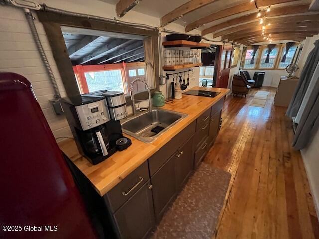 15-17 Pine Rd, Lake Luzerne, NY 12846 - kitchen with open shelves, a sink, wood-type flooring, black electric cooktop, and butcher block counters