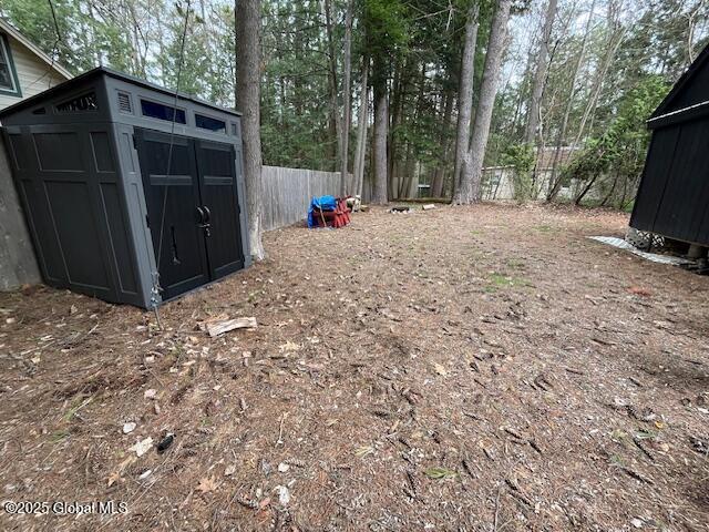 15-17 Pine Rd, Lake Luzerne, NY 12846 - view of yard with an outdoor structure, a fenced backyard, and a storage unit