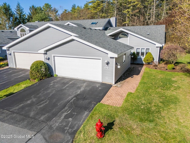 view of front of property featuring an attached garage, a shingled roof, a front lawn, and aphalt driveway
