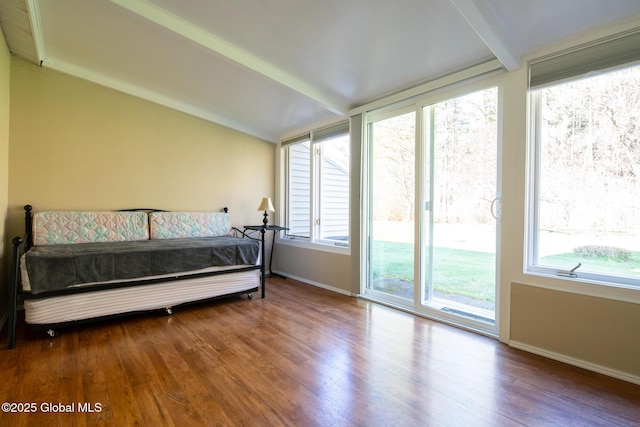 bedroom with baseboards, wood finished floors, and access to exterior