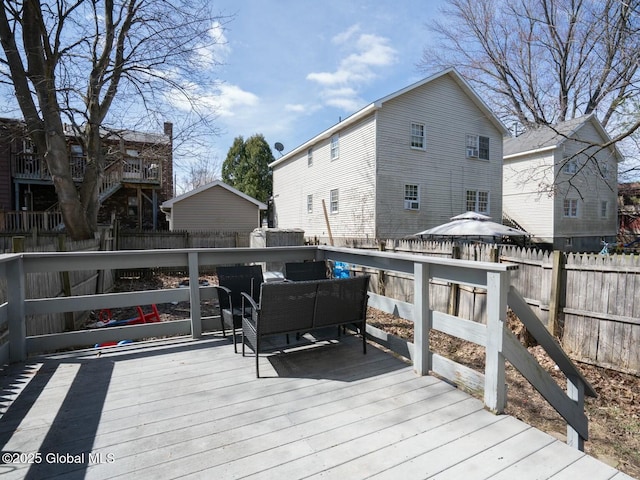 wooden terrace with an outdoor living space and a fenced backyard
