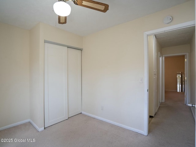 unfurnished bedroom featuring baseboards, a closet, light carpet, and ceiling fan
