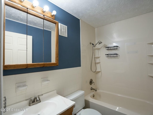 full bath with visible vents, shower / bathtub combination, toilet, tile walls, and a textured ceiling