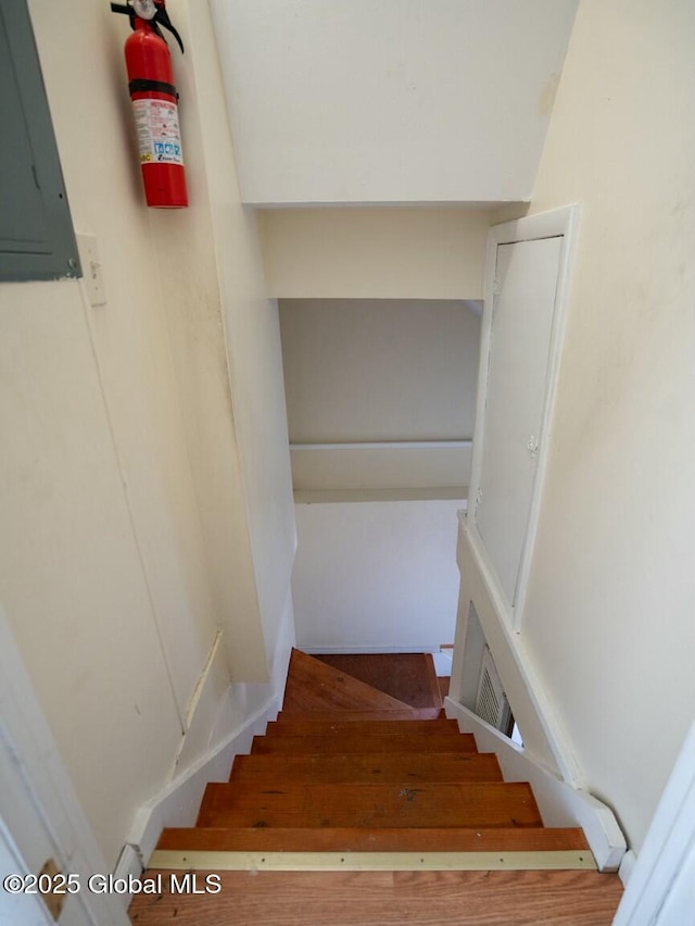 staircase featuring electric panel and visible vents