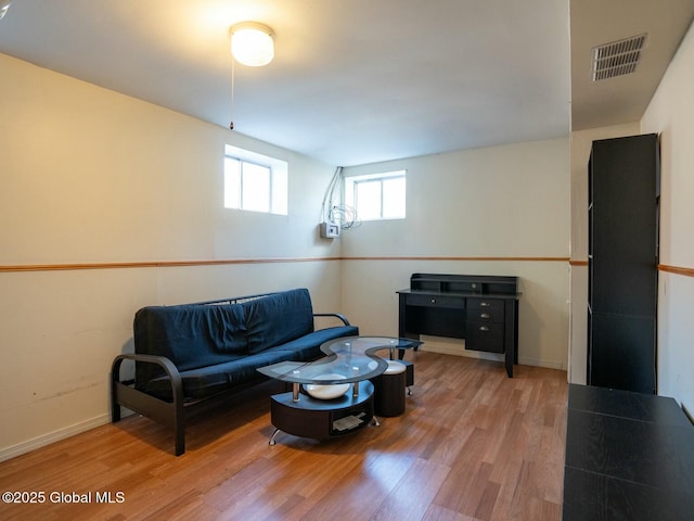 living area featuring baseboards, wood finished floors, and visible vents