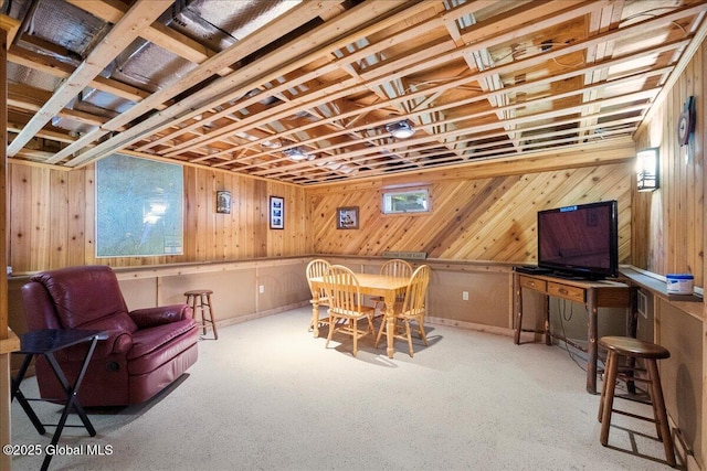 carpeted dining area with wooden walls