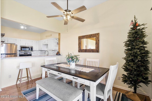 dining area with a ceiling fan and wood finished floors