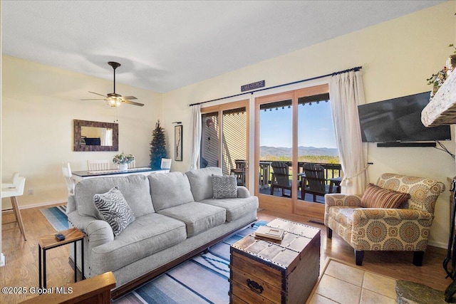 living room with baseboards, ceiling fan, and wood finished floors