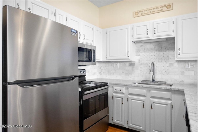 kitchen featuring a sink, white cabinets, tasteful backsplash, and stainless steel appliances