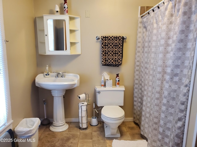 bathroom featuring tile patterned floors, baseboards, a shower with curtain, and toilet