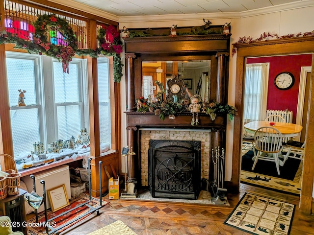 living room with ornamental molding and a fireplace with raised hearth