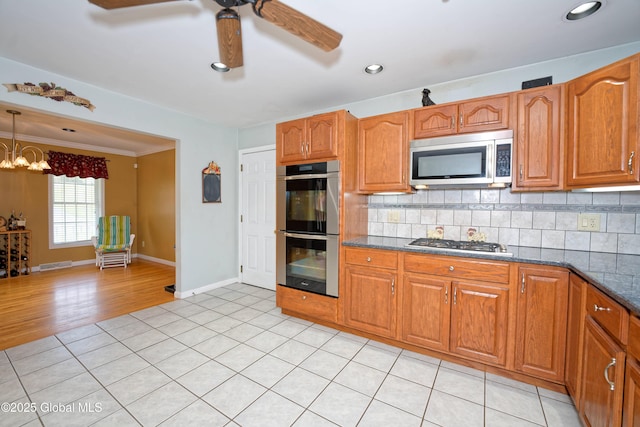 37 Old Hickory Rd, Brunswick, NY 12180 - kitchen with brown cabinetry, baseboards, ceiling fan with notable chandelier, stainless steel appliances, and tasteful backsplash