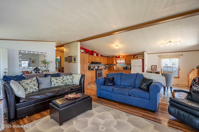 living area featuring light wood-style floors, crown molding, and lofted ceiling