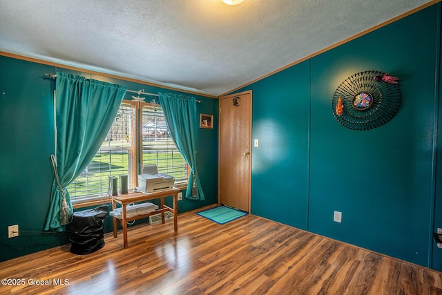 unfurnished room featuring crown molding, a textured ceiling, and wood finished floors