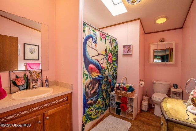 bathroom with a shower with curtain, vanity, toilet, wood finished floors, and a skylight