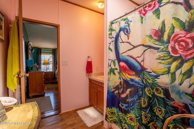 full bathroom featuring vanity, curtained shower, baseboards, and wood finished floors