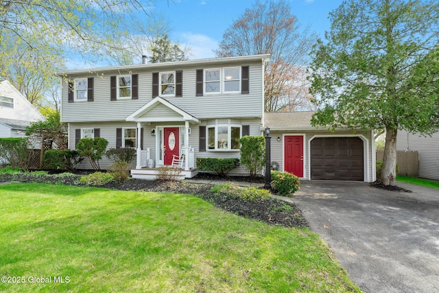 colonial inspired home with an attached garage, a front yard, and aphalt driveway