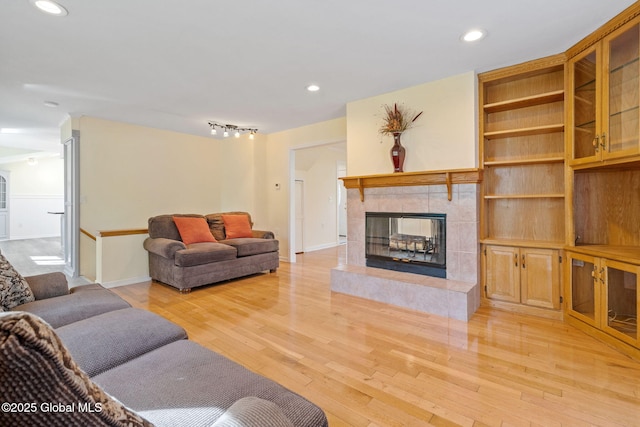 living room with recessed lighting, baseboards, light wood finished floors, and a fireplace